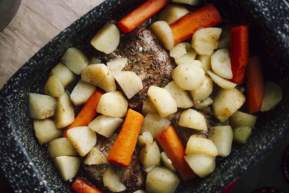 Carne y verduras asándose en una fuente