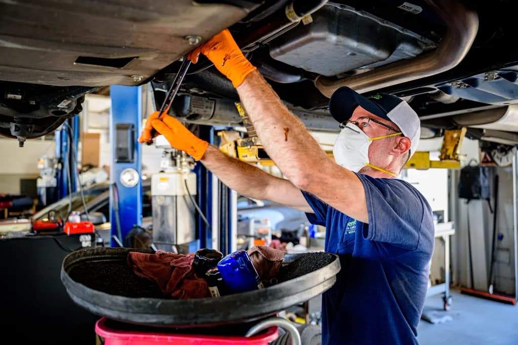 Mecánico trabajando bajo un vehículo elevado
